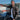 Model wearing Cockpit USA Men's Horsehide A-2 Jacket while standing next to small aircraft