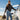 Woman wearing Cockpit USA Women's Amelia leather jacket standing on aircraft wing holding flight helmet