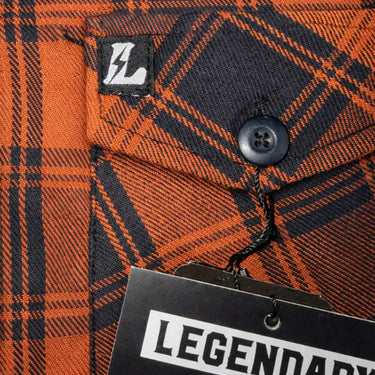 Legendary No Life series flannel shirt chest label close-up on orange and black plaid fabric