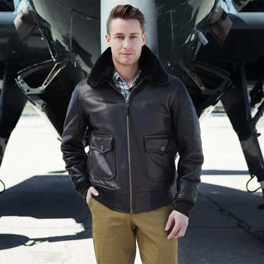 Male model wearing the G-1 Calfskin Leather Jacket standing in front of an aircraft