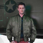 Model wearing Cockpit USA Men's MA-1 Nylon Flight Jacket in olive green in front of military aircraft