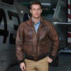 Man wearing the Mustang A-2 leather flight jacket standing in front of an aircraft