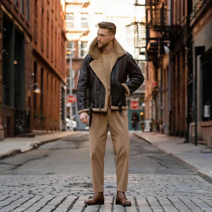 Model standing in the middle of a cobblestone street wearing the full RAF Sheepskin Bomber outfit.