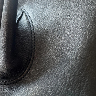 Close-up detail of premium black deerskin leather texture and stitching on Legendary USA fingerless ventilated motorcycle gloves, made in USA