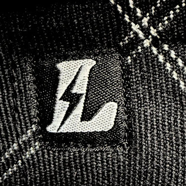 Legendary No Life series flannel chest label close-up with bolt logo on textured fabric